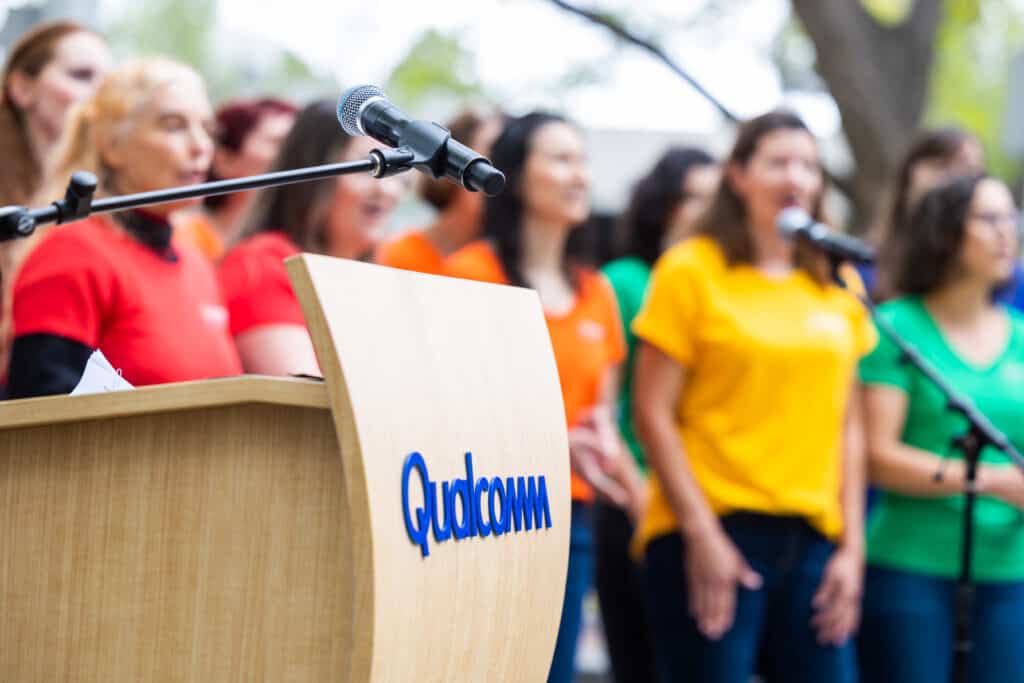 SDWC singing with a Qualcomm logo in the foreground